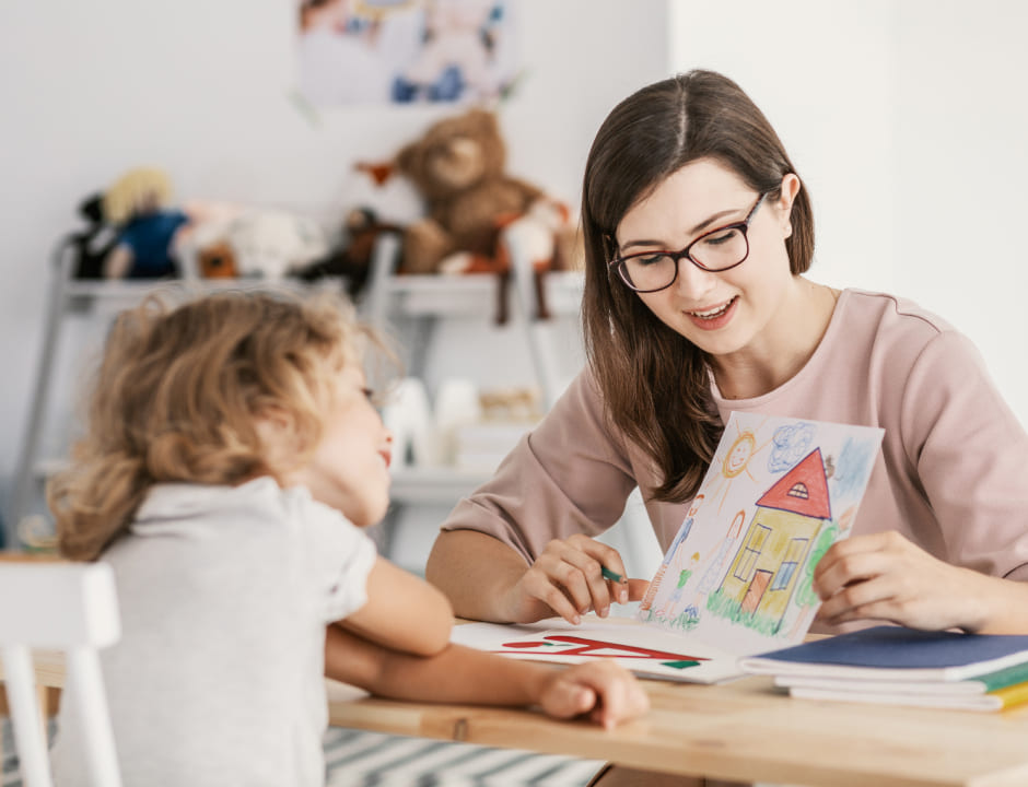 Education student showing a drawing to a child